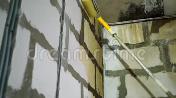 工人在施工现场搅拌黄色底漆到刷墙公寓或房屋的翻新和维修视频的预览图