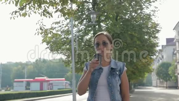 一个年轻漂亮的女孩在城市里到处喝咖啡的肖像视频的预览图
