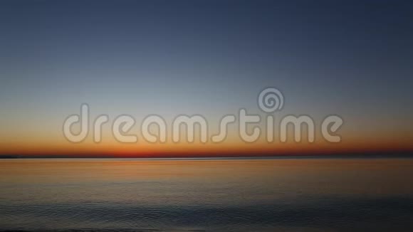 日出时平静的大海小浪带着鹅卵石在海滨翻滚视频的预览图