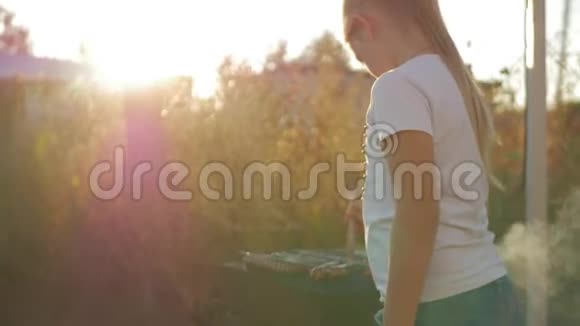 小女孩在绿色草坪的烤架上做烧烤视频的预览图