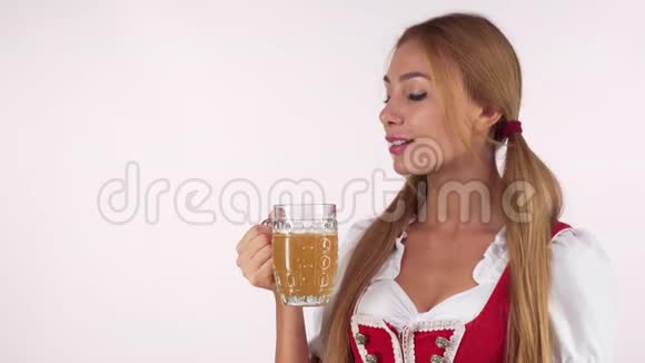 快乐美丽的啤酒节女人喝着啤酒对着镜头微笑视频的预览图