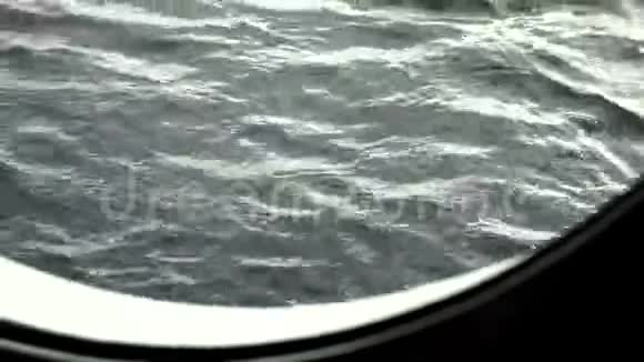 清晨在游轮上通过一个大圆舷窗可以看到船的俯仰和波浪视频的预览图