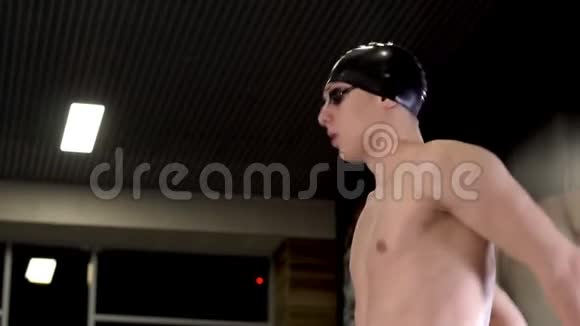 戴着帽子和眼镜的专业游泳运动员在游泳前热身视频的预览图