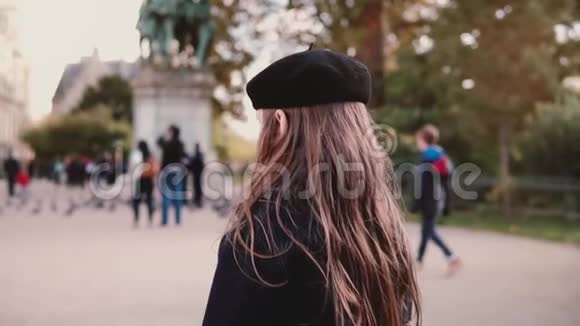 贝雷帽里的小女孩独自站在城市广场上后景慢动作长发的女孩子还在等着视频的预览图