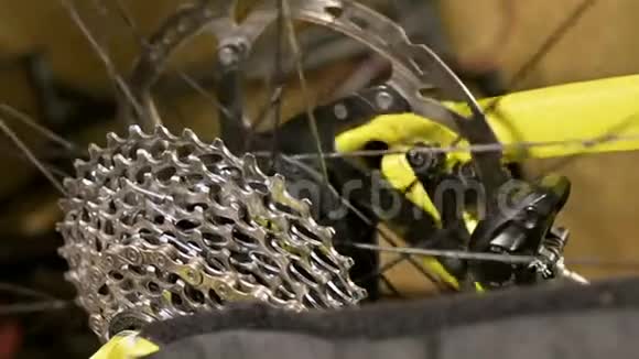 在自行车修理车间里一个带制动盘的支架上旋转特写车轮自行车修理视频的预览图