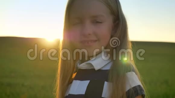 金发美女对着镜头微笑夕阳映衬下的田野幸福快乐视频的预览图