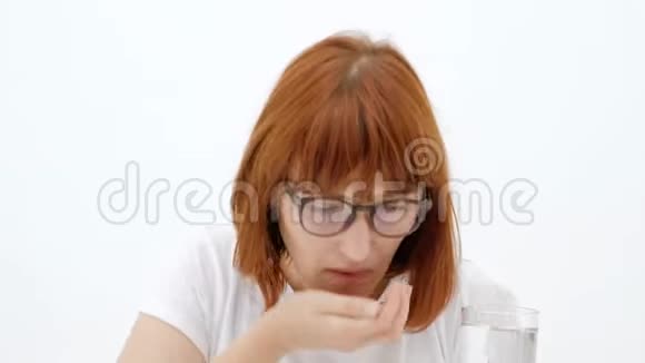 女人手里拿着指指点点的药年轻女孩服用药物视频的预览图