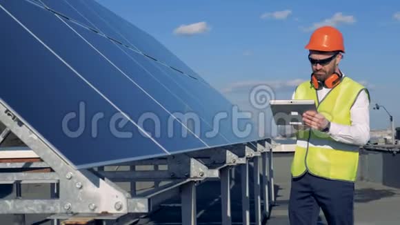 太阳能电池板由一位男性工作服专家检查视频的预览图