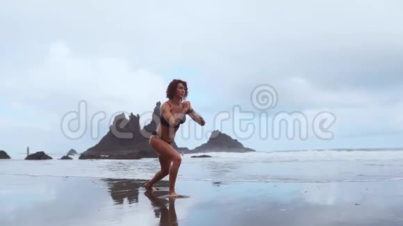 弯曲的腿沿着海洋行走训练腿部肌肉的耐力使大腿牢固海洋附近的女孩视频的预览图