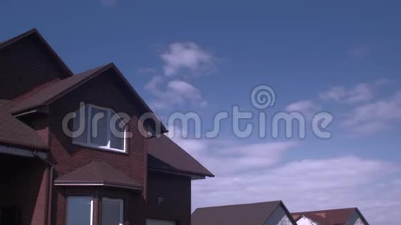 蓝天中的时间流逝的云笼罩在刚出炉的房子的屋顶上视频的预览图