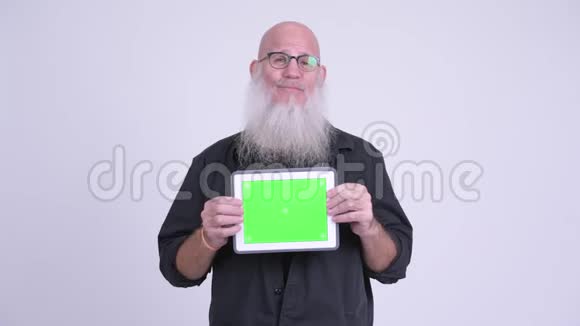 成熟的秃头男人展示数码平板电脑视频的预览图