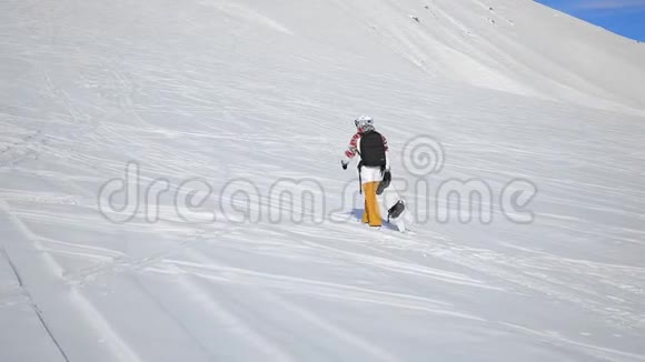 滑雪板在雪山和蓝天上行走视频的预览图