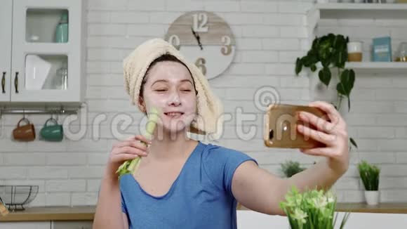带面具的女孩自拍吃厨房里的芹菜视频的预览图