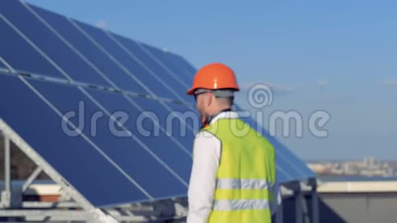 男性专家正在从太阳能电池板上移开举起头盔替代能源概念视频的预览图