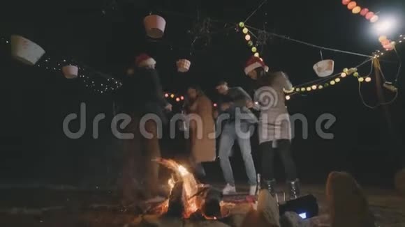朋友们围着露营火跳舞庆祝新年视频的预览图