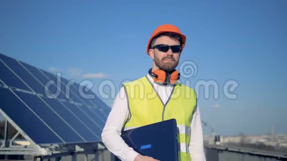 男工程师正拿着笔记本电脑站在太阳能电池板的背景下视频的预览图