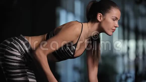 在健身房用哑铃锻炼的年轻女子视频的预览图