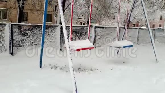 冬季暴风雪后操场上的秋千覆盖着雪没有孩子在玩视频的预览图