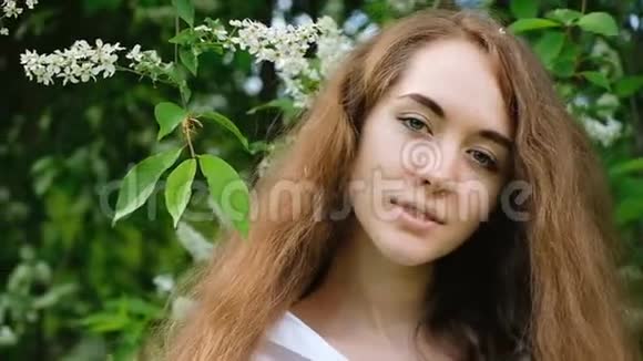 一个欧洲女孩的肖像在大自然中长着流动的头发动作缓慢美丽可爱的年轻女子摆姿势视频的预览图