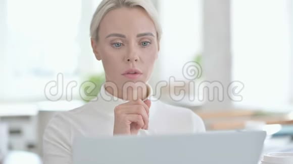 年轻女商人在笔记本电脑上思考和工作的肖像视频的预览图