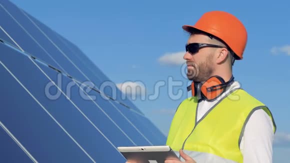 男工程师正在看太阳能电池板并在他的电脑中注意到一些东西视频的预览图