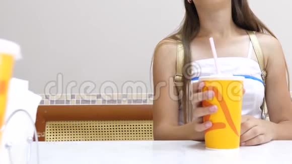 女人坐在咖啡馆的桌子上喝鸡尾酒特写视频的预览图