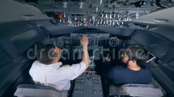 专业飞行员在驾驶飞行模拟器指导一个人视频的预览图