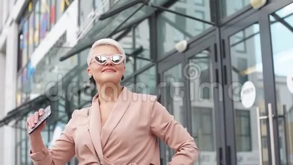 成熟的女性穿着夹克走在街头户外视频的预览图