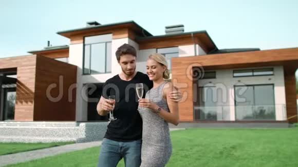 成功的男人和女人在豪宅外喝香槟视频的预览图