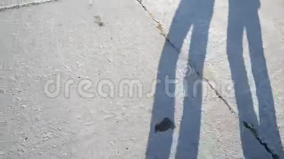 两名步行者在水泥石板路上的影子或轮廓视频的预览图