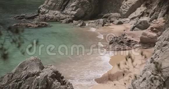 年轻的白种人白种人坐在岩石石上在夏季的海洋海滩上享受生活视频的预览图