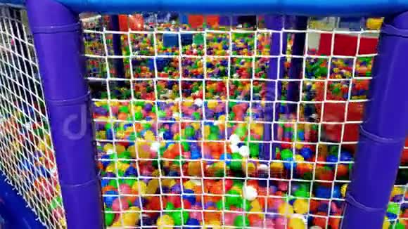 购物中心儿童游乐场的4K镜头里面有很多五颜六色的球为孩子们准备的大游泳池充满了五颜六色视频的预览图