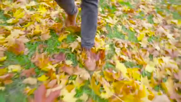 一个穿皮鞋的年轻人在落叶上奔跑视频的预览图