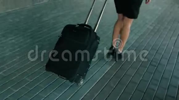 穿着黑色高跟鞋带旅行行李走路的瘦女人腿视频的预览图
