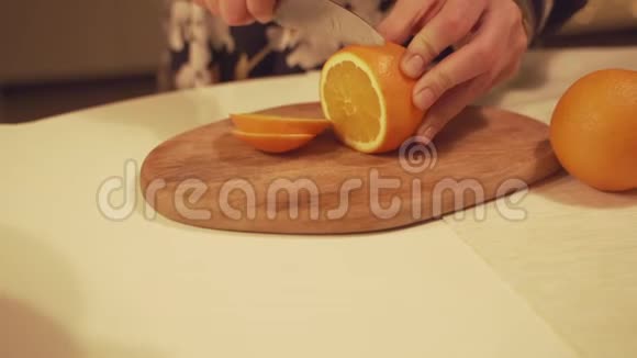 双手切橘子在砧板上用于自制橙片蔓越莓肉桂覆盖葡萄酒视频的预览图