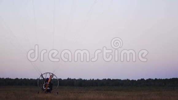 马达滑翔伞降落后将降落伞放下日落后完全停在野外视频的预览图