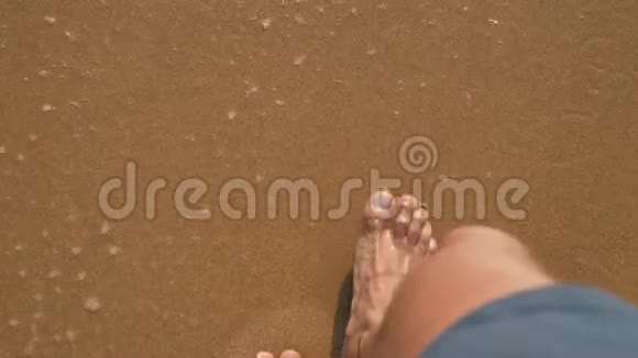 沙滩旅行人走着海浪沙滩在沙滩上留下脚印男性双脚特写细节特写视频的预览图