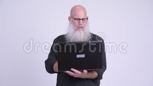 成熟的秃头男人在用笔记本电脑思考视频的预览图