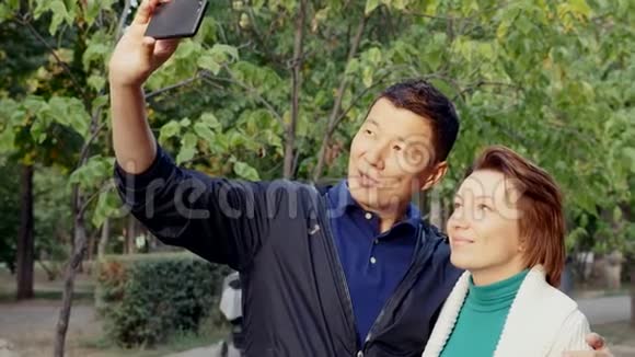 现代情侣在智能手机摄像头上自拍拥抱在一起视频的预览图