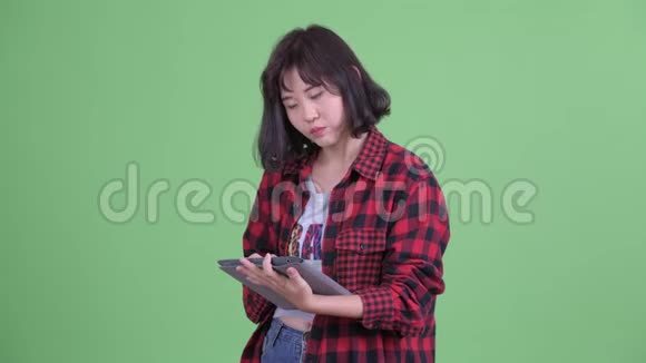 使用数码平板电脑的快乐亚洲潮女视频的预览图