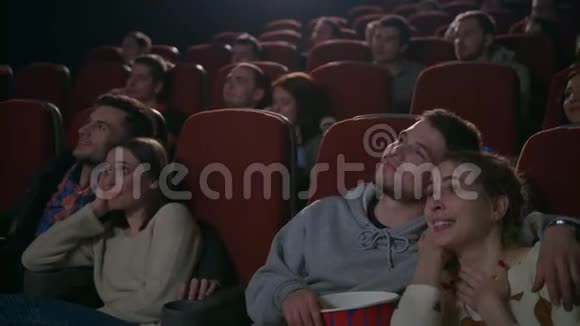 喜欢在电影院看电影的情侣吃爆米花的年轻人视频的预览图
