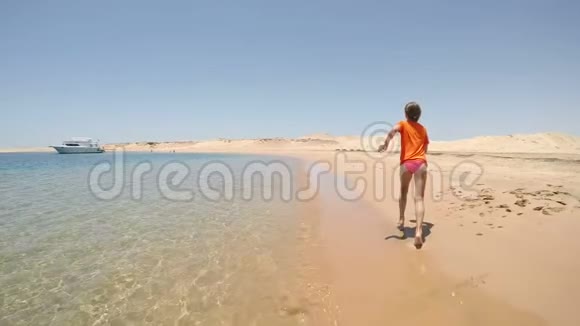 穿着泳装的女孩在沙漠中的海边奔跑视频的预览图