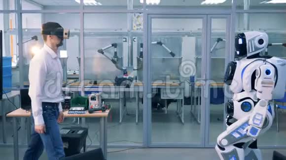 一个戴着虚拟眼镜的男人和一个机器人正在给对方击掌视频的预览图