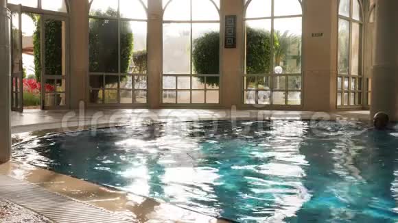 男子用照明弹在淡水中游泳在室内游泳池休息视频的预览图