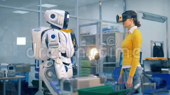 机器人类人正在对一个戴着虚拟现实眼镜的女士进行一次击掌视频的预览图