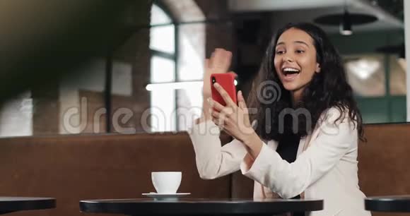 快乐的商务女性在舒适的咖啡馆通过视频聊天会议在电话交谈商业女性视频的预览图