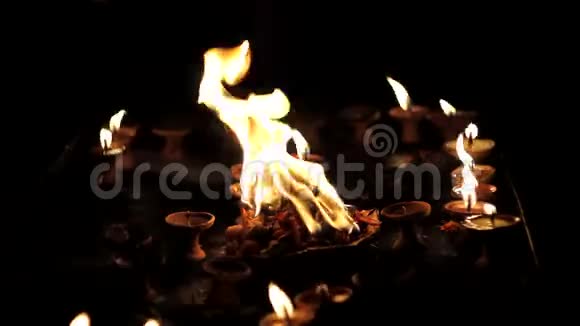 排灯节假期一个盘子里有燃烧的花背景是粘土中的小蜡烛矗立在黑暗中视频的预览图