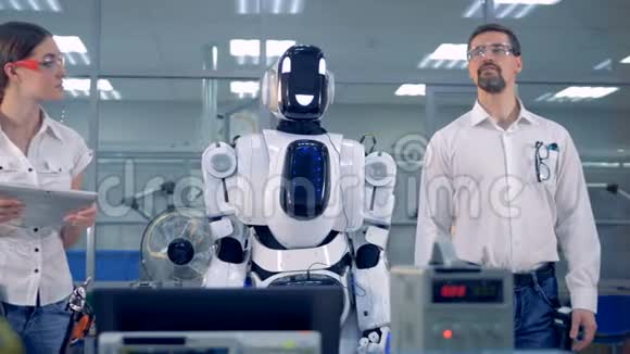 机器人类人在一名男性工程师的带领下转动头部视频的预览图