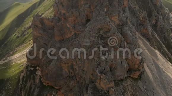 傍晚日落时专业鸟瞰一座岩石山尖崖极限攀登概念视频的预览图
