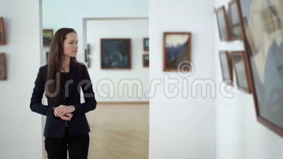 城市美术馆展览艺术绘画作品优雅美丽的女人看博物馆里的照片视频的预览图